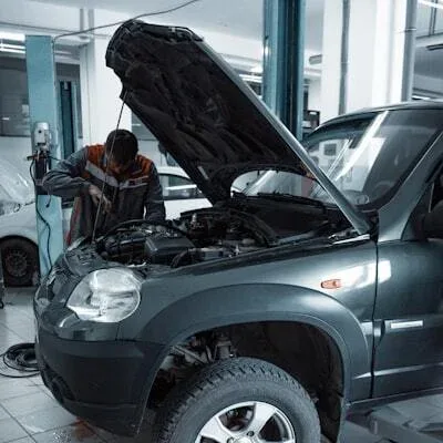 Mechanic inspecting the engine bay of an SUV at JASRAUTO workshop in Sharjah